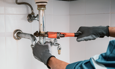plumber using wrench repair water pipe sink 1